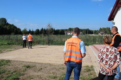 Plac przy świetlicy wiejskiej w Chustkach, podczas odbioru. Komisja na pierwszym planie.